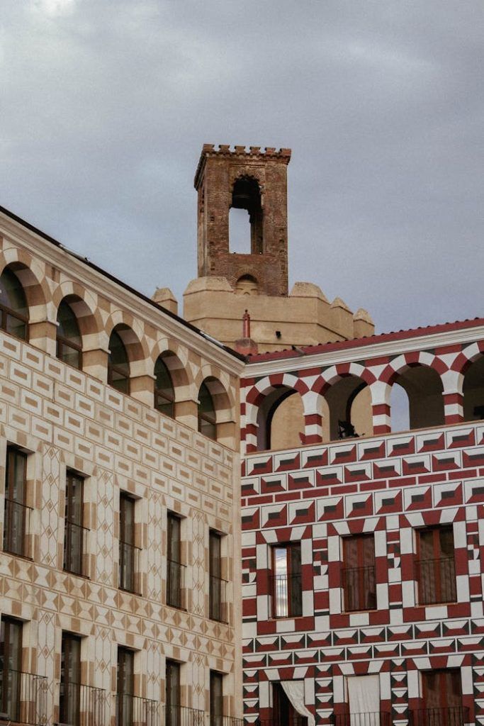 Historic buildings with intricate patterns and a tower in Badajoz, Spain.